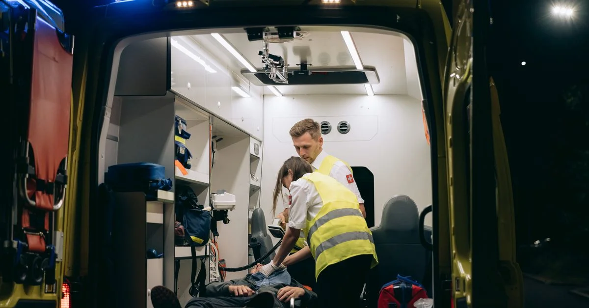 Des ambulanciers assistent un patient à l'intérieur d'une ambulance, fournissant une assistance médicale d'urgence pendant la nuit.